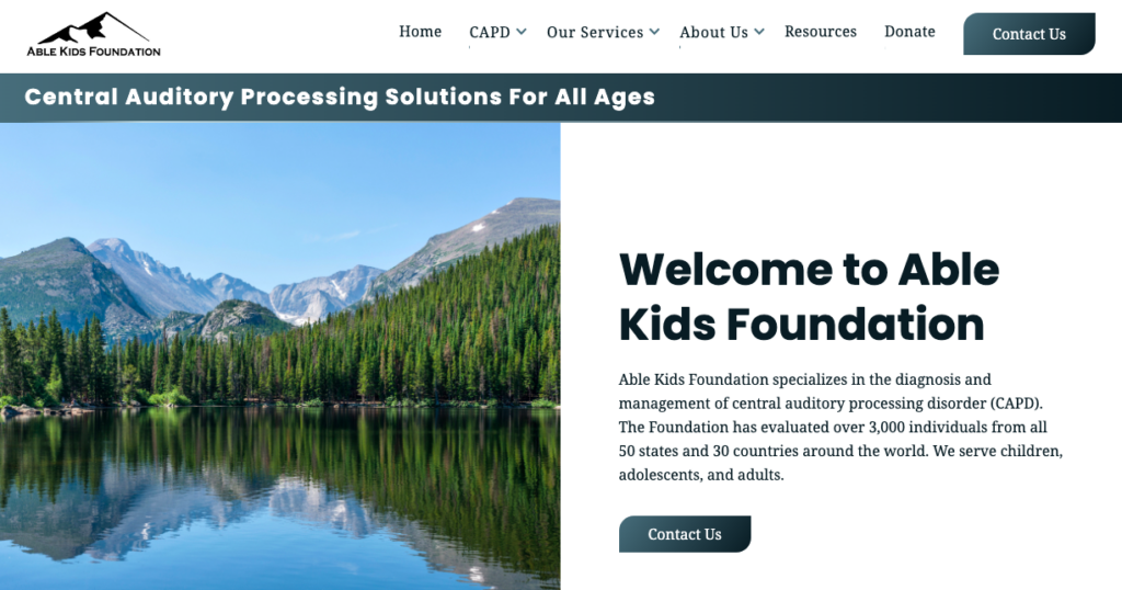 Homepage for Able Kids Foundation's new website, featuring a calm river surrounded by a forest fo pine trees.