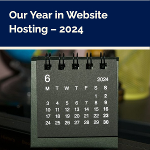 A gray desk calendar with white numbers sits on a table. Text at the top reads: Our Year in Website Hosting - 2024